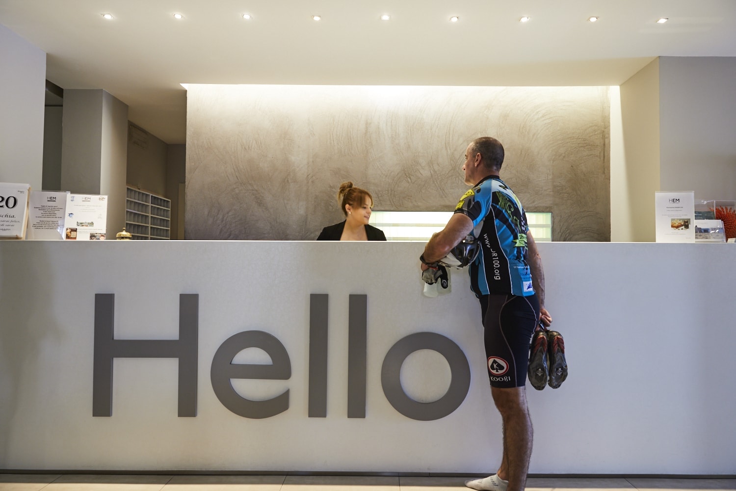 Cyclist checking in at a hotel reception after a day of riding
