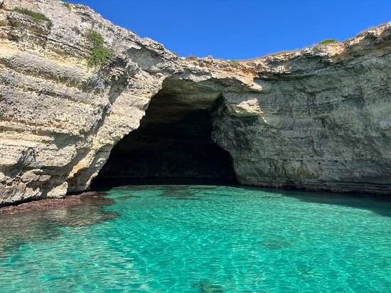Sea cave with turquoise water on the coast of Puglia seen from a boat